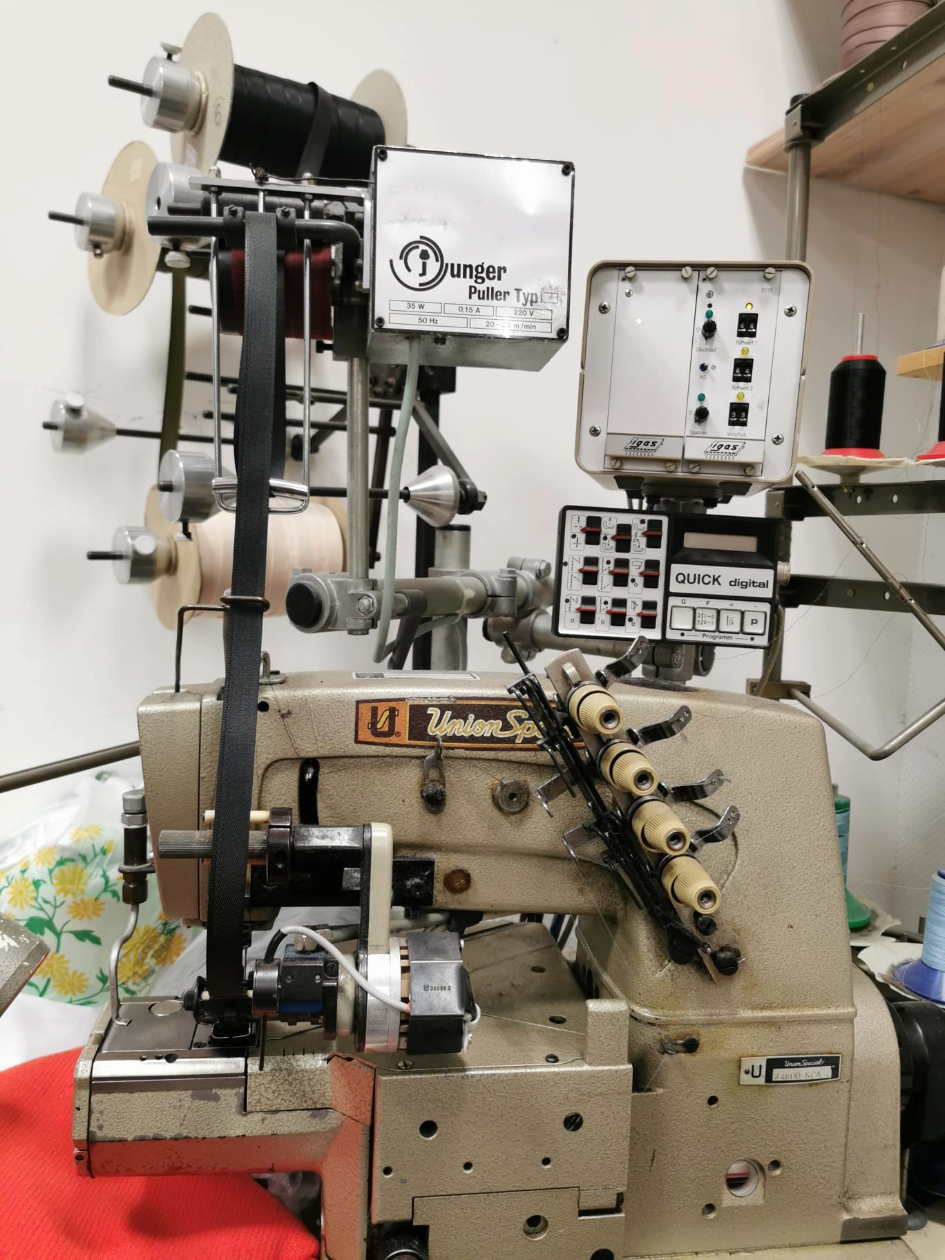 Kansai Special Spezialnähmaschine vor einer Wand mit hunderten Garnrollen